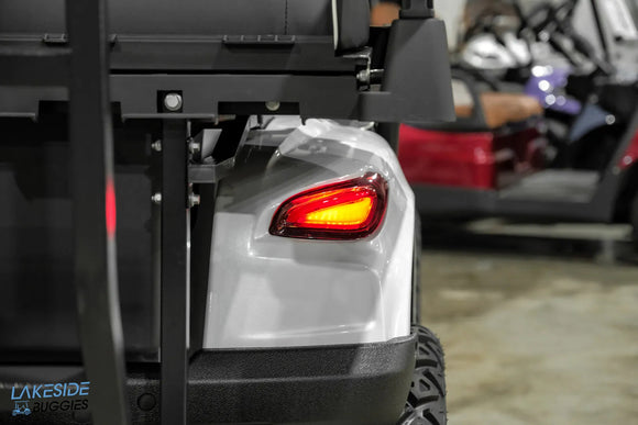 Gray golf cart with illuminated taillight.