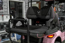 Pink golf cart with black seats.