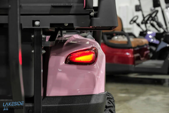 Pink golf cart with illuminated taillight.