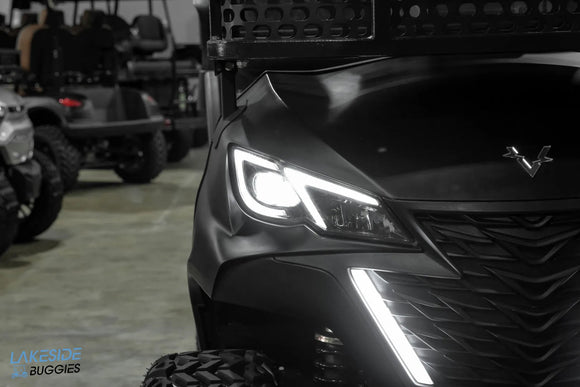 Black golf cart with illuminated headlights.
