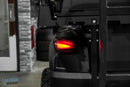 Black golf cart with illuminated taillight.