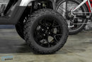 Black off-road tire with a multi-spoke rim.