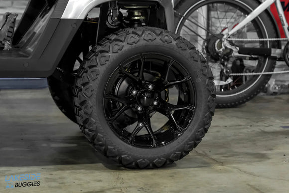 Black off-road tire with a multi-spoke rim.