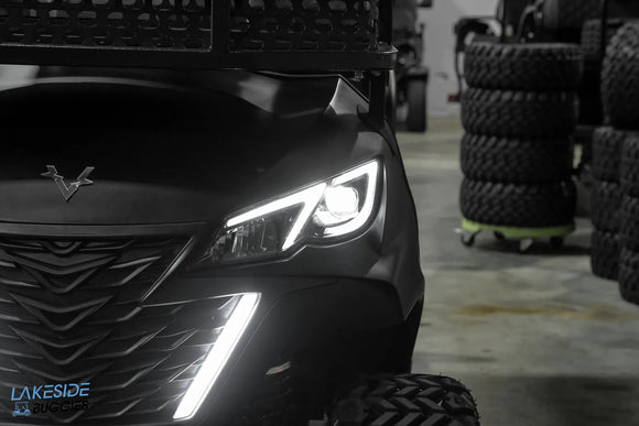 Black off-road vehicle with illuminated headlights.