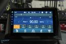 Car radio display showing FM frequency.
