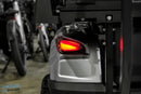 Silver golf cart with illuminated taillight.
