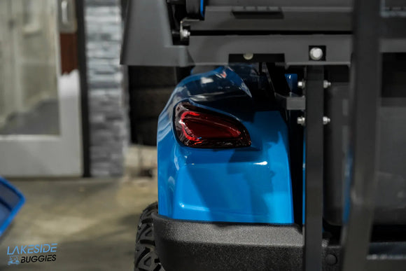 Blue golf cart rear with red taillight.