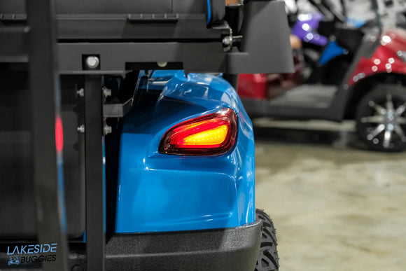 Blue golf cart with illuminated taillight.