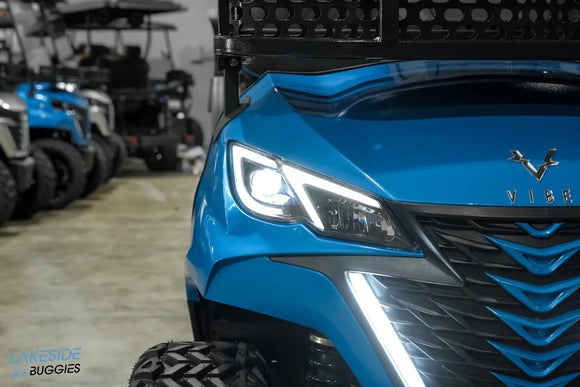 Blue golf cart with distinctive lighting.