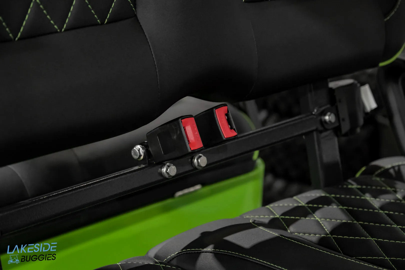 Black seatbelt bar with red release buttons.